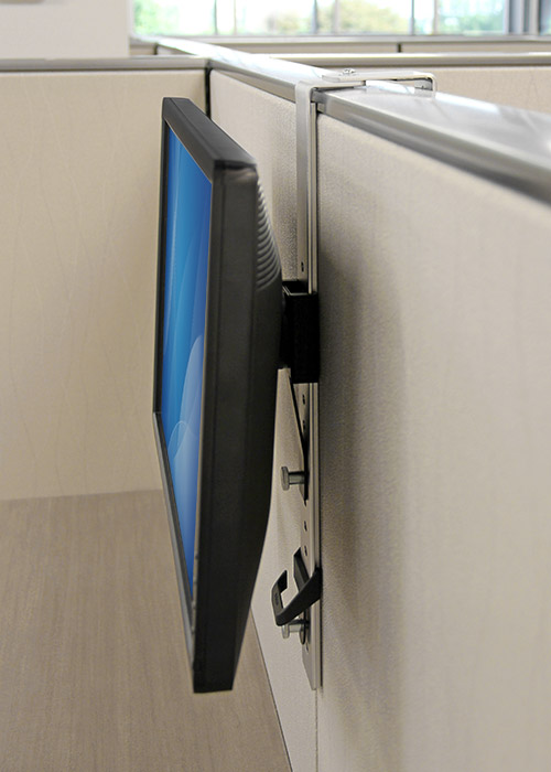 Vista lateral de un monitor que cuelga sobre la pared de un cubIculo, mediante el soporte ARMCBCL