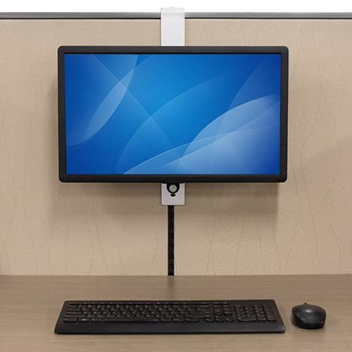 A monitor hanging over a cubicle wall using the ARMCBCL at a desk with a keyboard and mouse