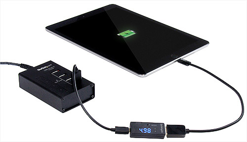 Carga de un iPad en una estación de carga de 4 puertos, con el comprobador que muestra el consumo de potencia y voltaje
