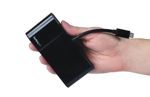 Imagen que muestra un adaptador multipuerto sostenido en la palma de una mano