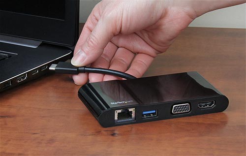 Foto toont de multiport adapter die wordt aangesloten op de USB-C poort van een laptop 