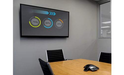 A large flat-panel TV mounted to a boardroom wall using the FLATPNLWALL TV wall mount